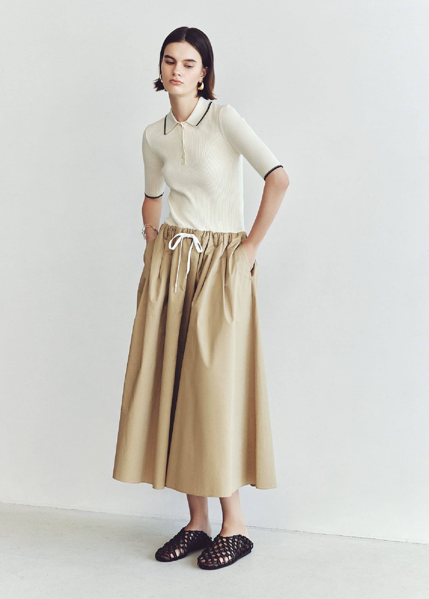 ポロNT×タックフレアSKドッキングOP&メタルドロップピアス&パールチェーンブレス&メッシュバレエを着用した女性