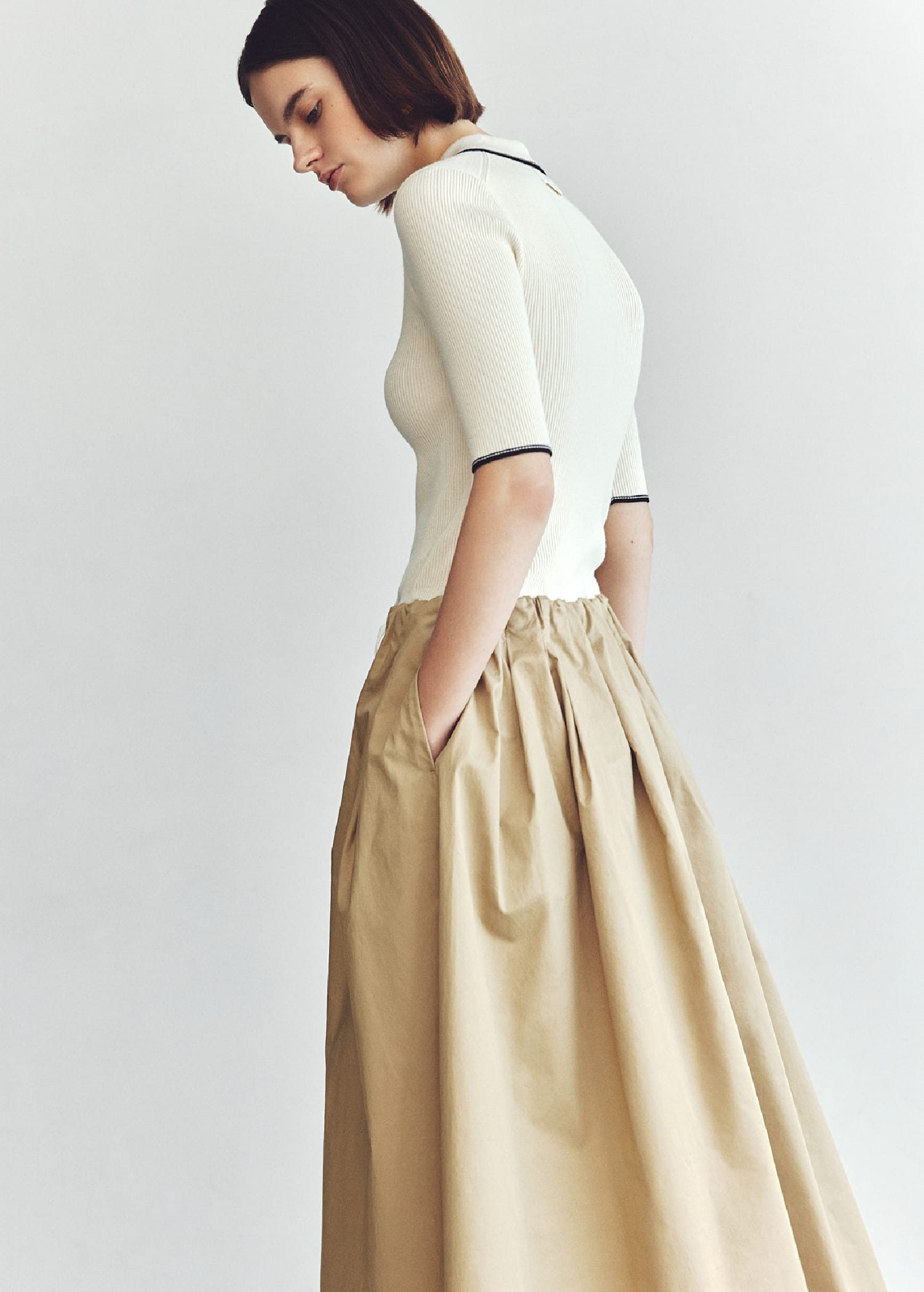 ポロNT×タックフレアSKドッキングOP&メタルドロップピアス&パールチェーンブレス&メッシュバレエを着用した女性