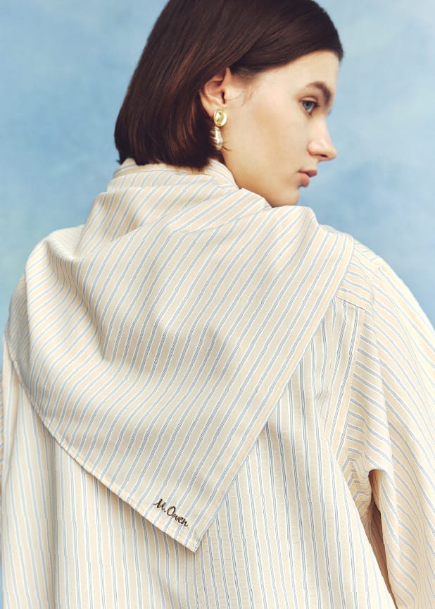 スカーフ付きストライプワークシャツ&２タックウエストゴムワイドイージーPT&ショートヘムケーブルニット&メタルモチーフパールイヤリング&タッセルローファーを着用した女性