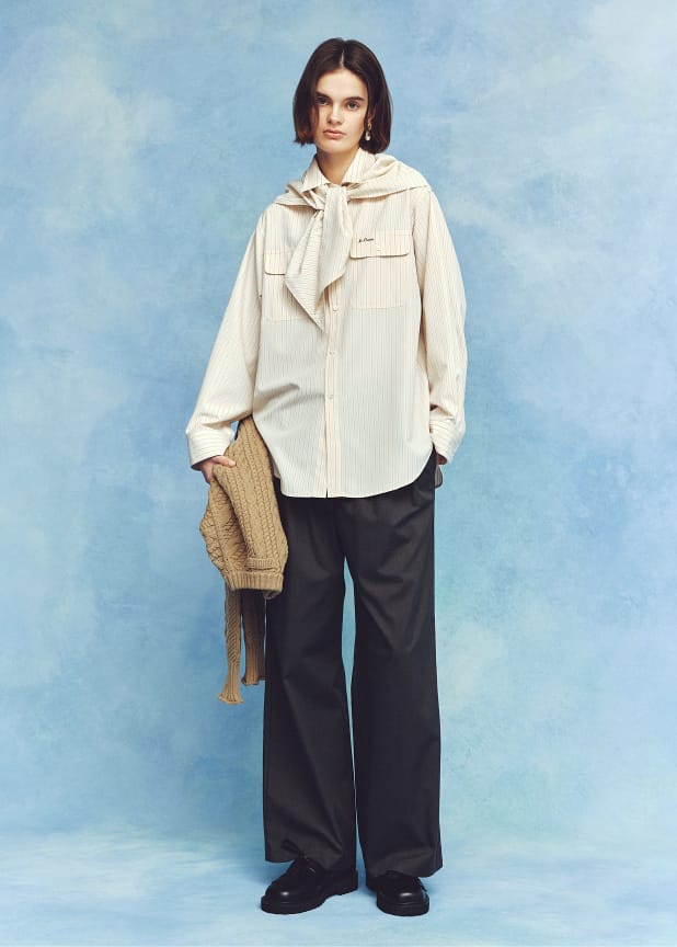 スカーフ付きストライプワークシャツ&２タックウエストゴムワイドイージーPT&ショートヘムケーブルニット&メタルモチーフパールイヤリング&タッセルローファーを着用した女性