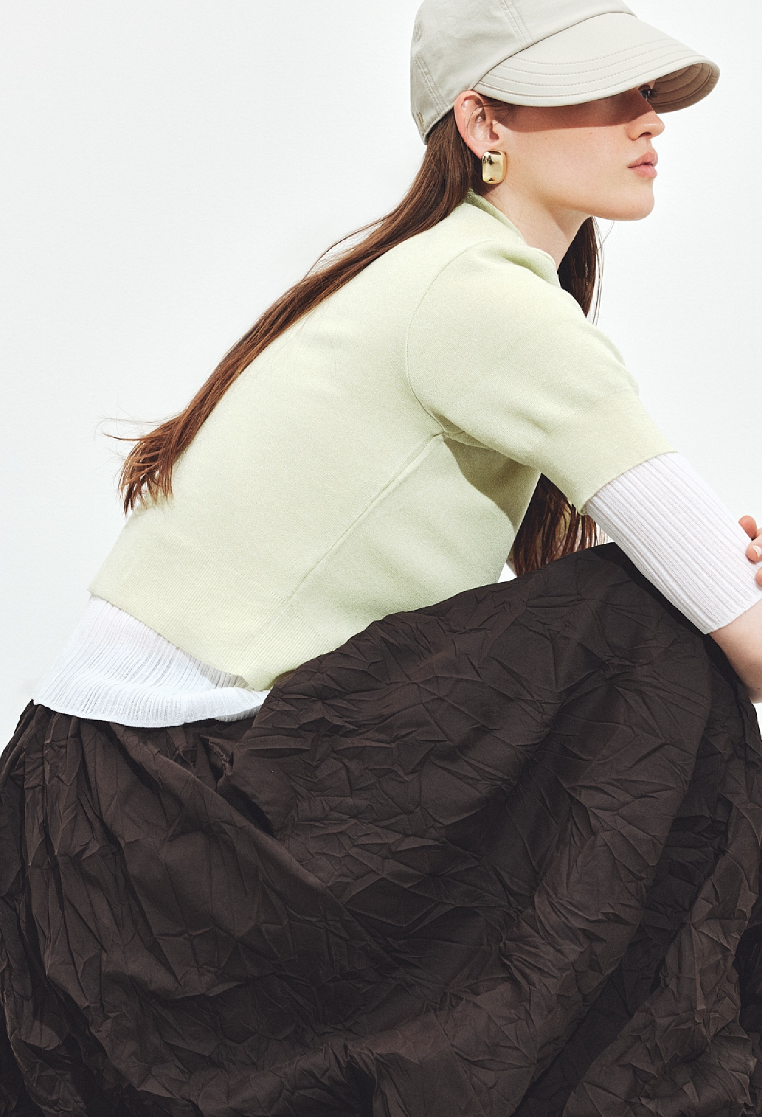 キャメルのサッカーストライプボリュームスカート・ゴールドのイヤリングとネックレスとバングル・キャメルのメリージェーンスニーカーを合わせたコーディネート