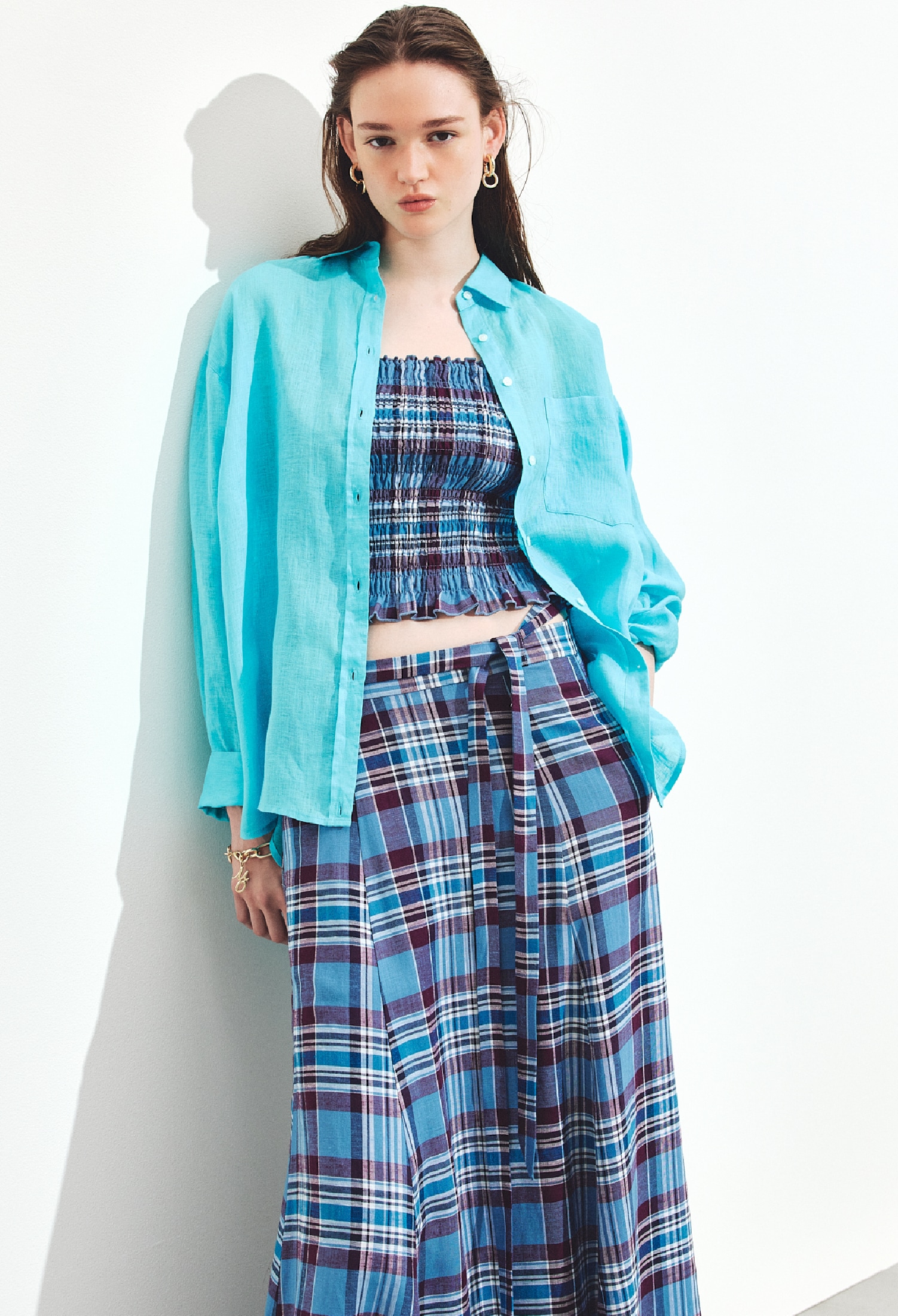 ブルーのマドラスチェックキャミソールとマドラスチェックサーキュラースカート・ポケット付きフレンチリネンシャツ・ゴールドのイヤリングとブレスレットを合わせたコーディネート