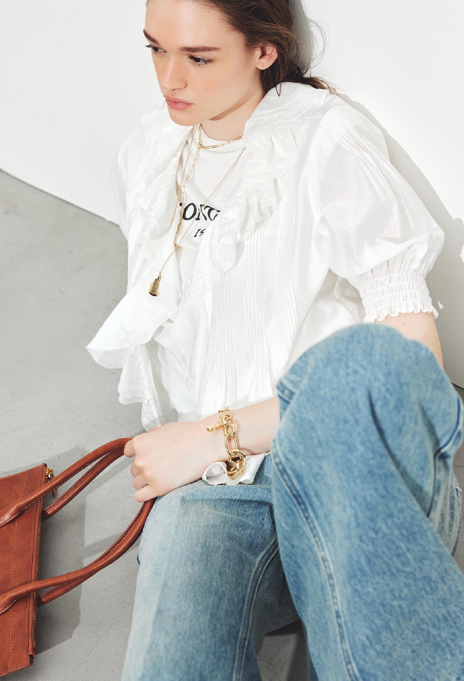 白のラッフルカラーブラウスとノースリーブTシャツ・ライトブルーのセンタープレスフレアデニムパンツ・ネックレスとブレスレット・キャメルのトートバッグ・ストラップサンダルを合わせたコーディネート