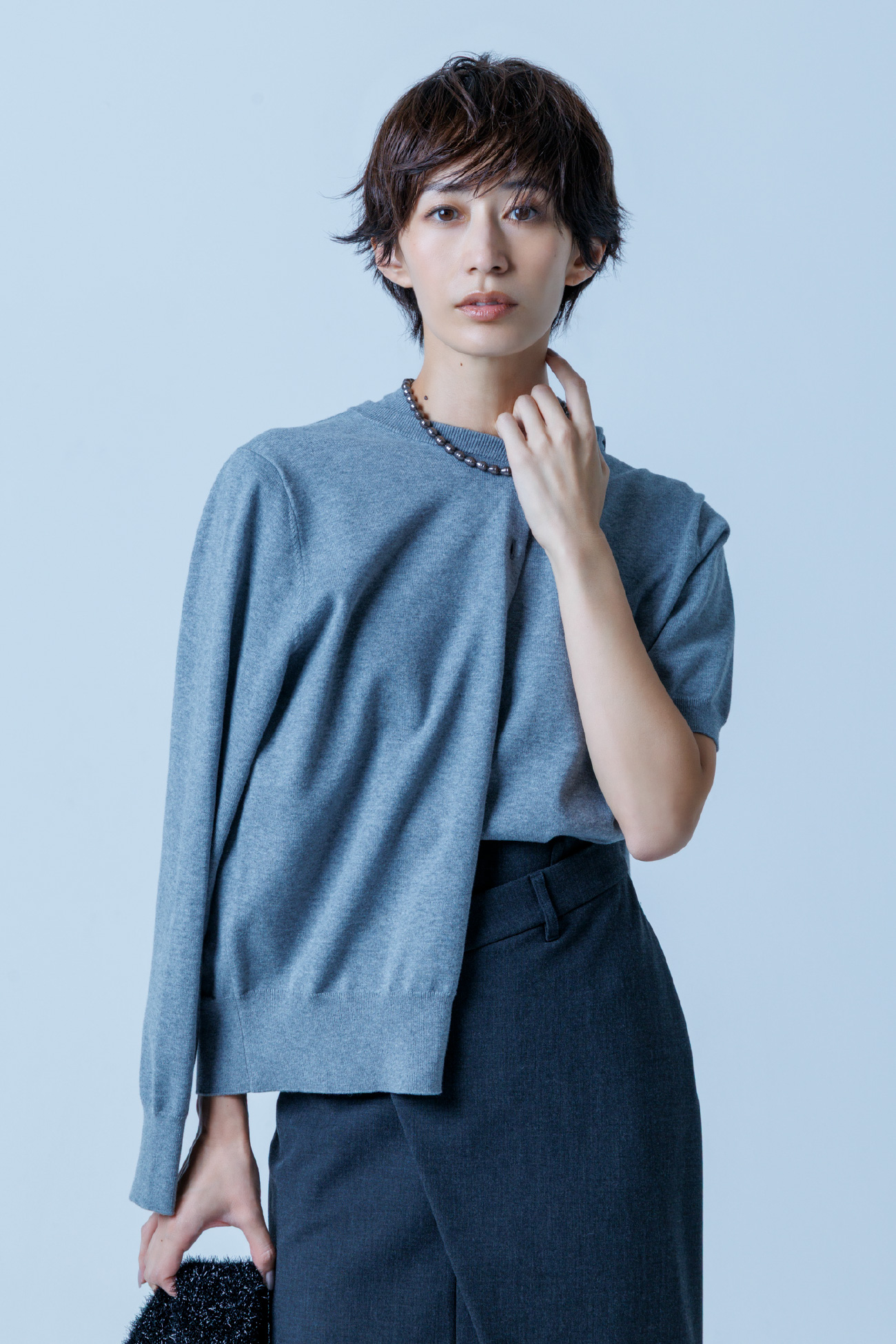 gray色の【お年玉】アンサンブルニット／カーディガンとアシメストレートスカート、変形パールネックレスを着用したモデル画像