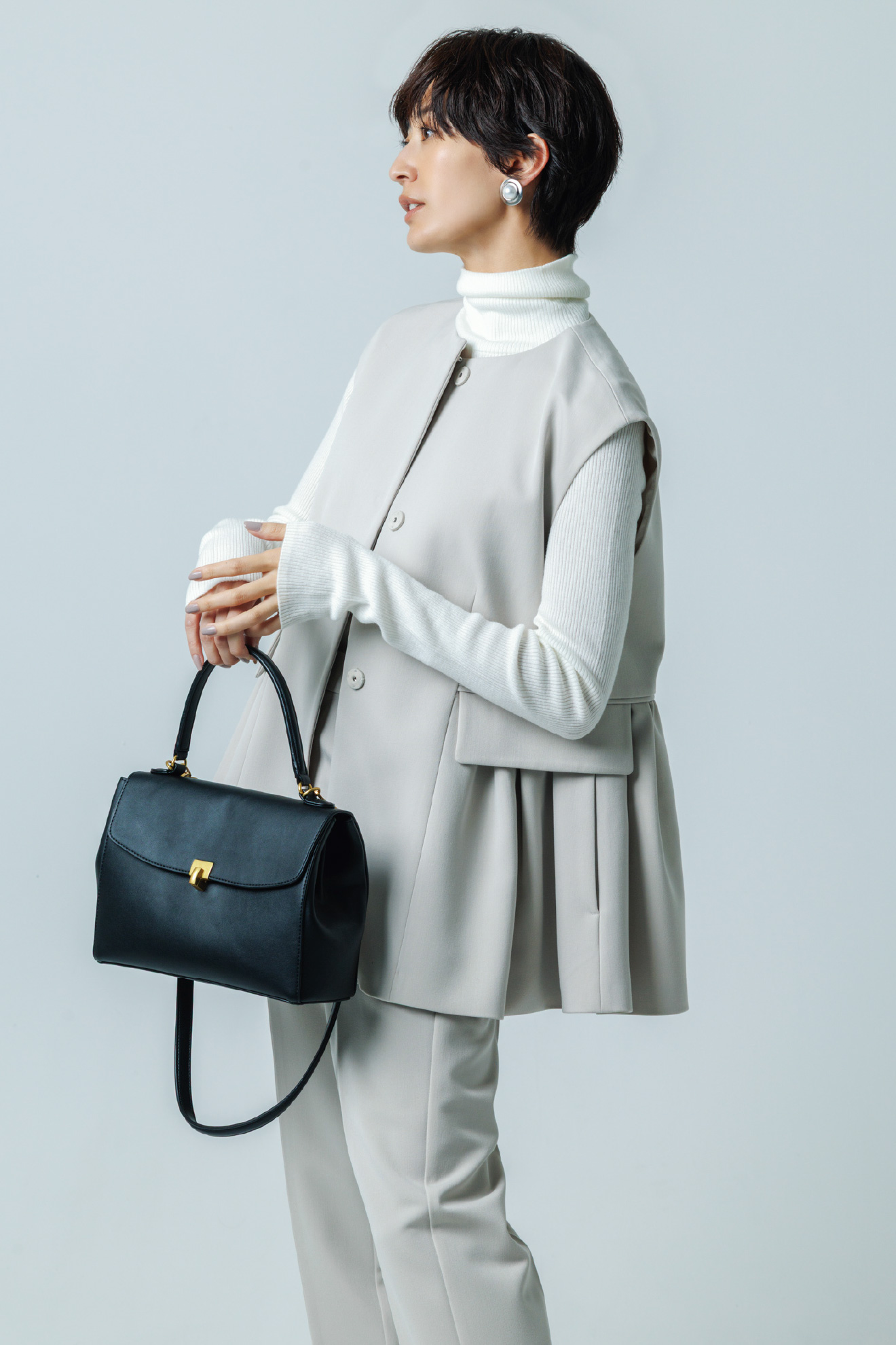 アイボリー色の【お年玉】ベスト×ニットプルオーバー×パンツ 3点SETとヴィンテージメタルポイントイヤリング、メタルモチーフスクエアバッグを着用したモデル画像