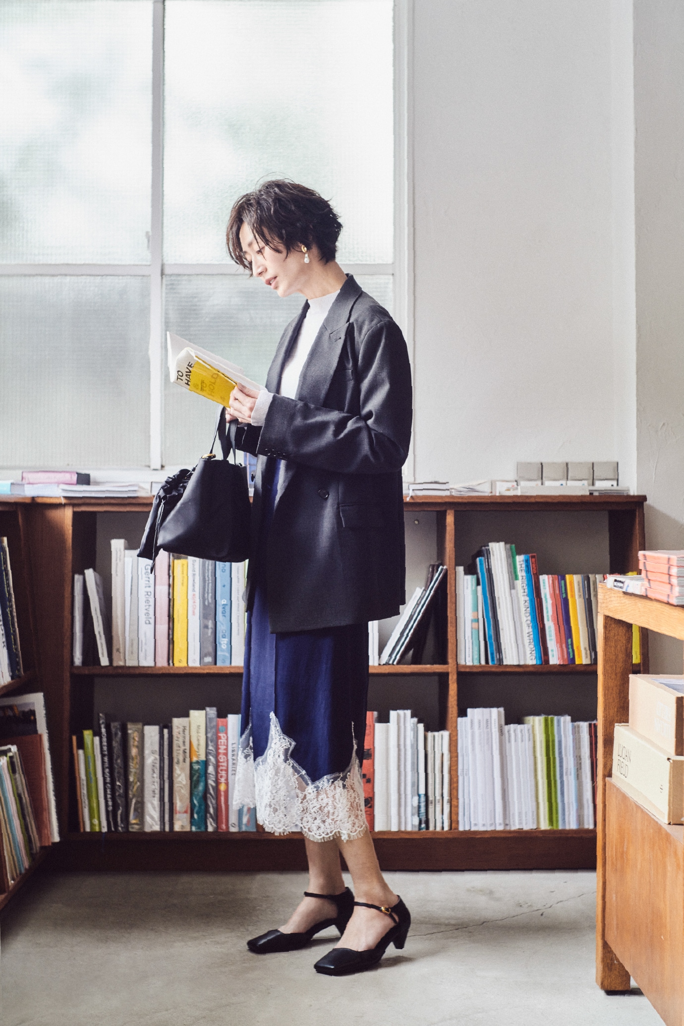 ブルーのクロップドフォルムカーディガンとスカラップレース衿ニットＰＯ・チャコールグレーのテーラードトラウザー・Aのメタルモチーフパールイヤリング・CMLのボディバッグ・黒のバックル付きラムレザースリングパンプスを合わせた、スタイリッシュな魅力が際立つコーディネート