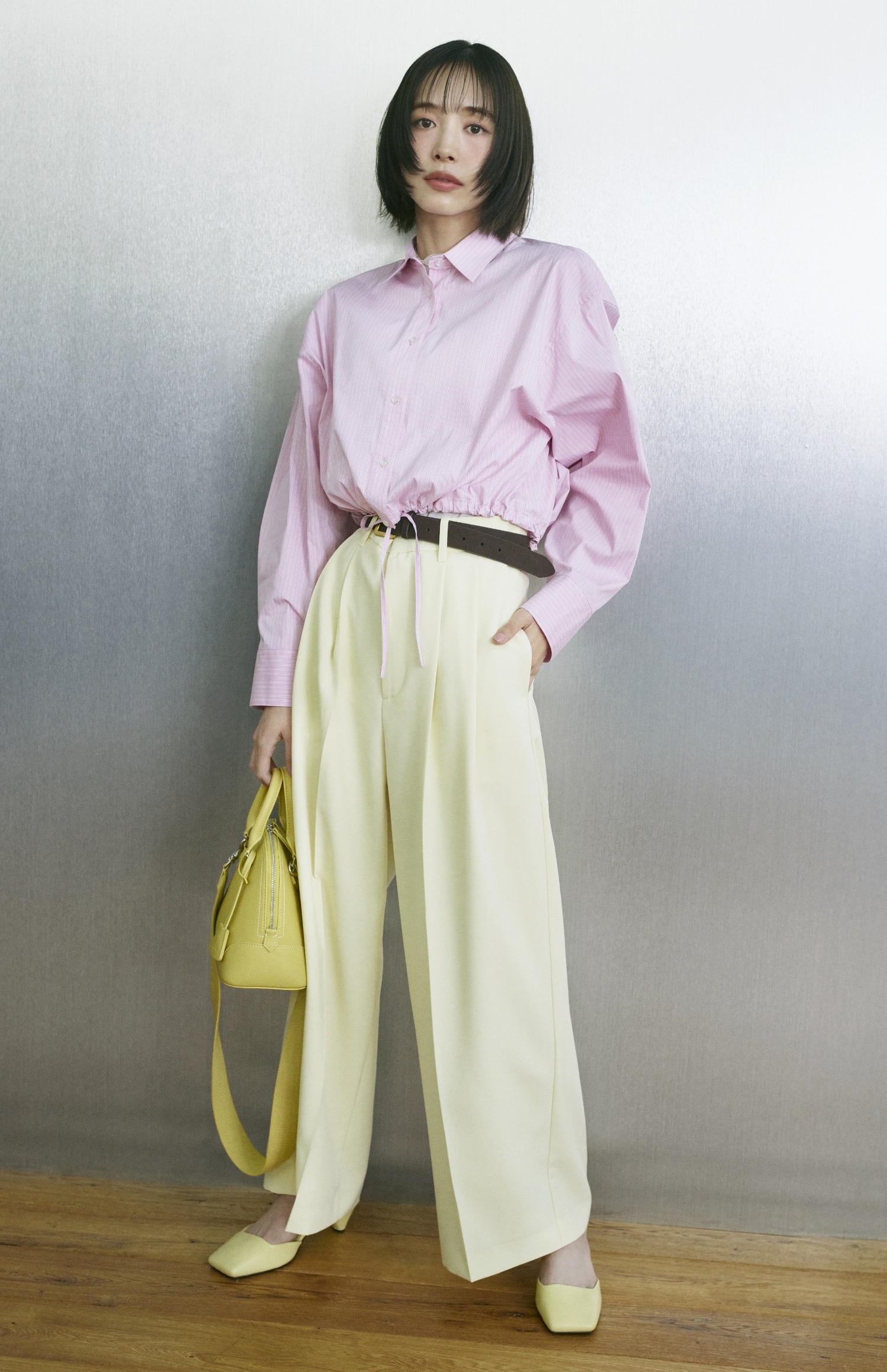 ピンクのストライプドロストショートシャツ・白のウールテンセルハーフスリーブシアーＴ・イエローの【井桁さんコラボ】２タックワイドパンツ・２連パールチェーンネックレス・ブラウンのスクエアバックルベルト・イエローのワイドショルダーミドルボストンバッグとアンクルストラップパンプスを合わせたコーディネート