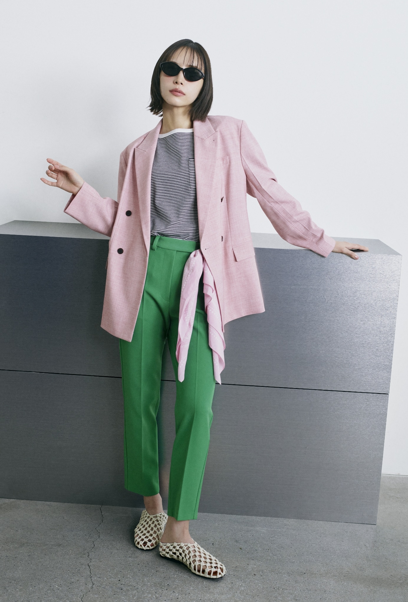 ピンクのダブルブレストテーラードジャケット・黒のボートネックコンパクトＴシャツ・グリーンの４サイズパンツ・黒のキャットアイサングラス・ピンクのバンダナ柄綿シルクスカーフ・アイボリーのメッシュバレエを合わせたコーディネート
