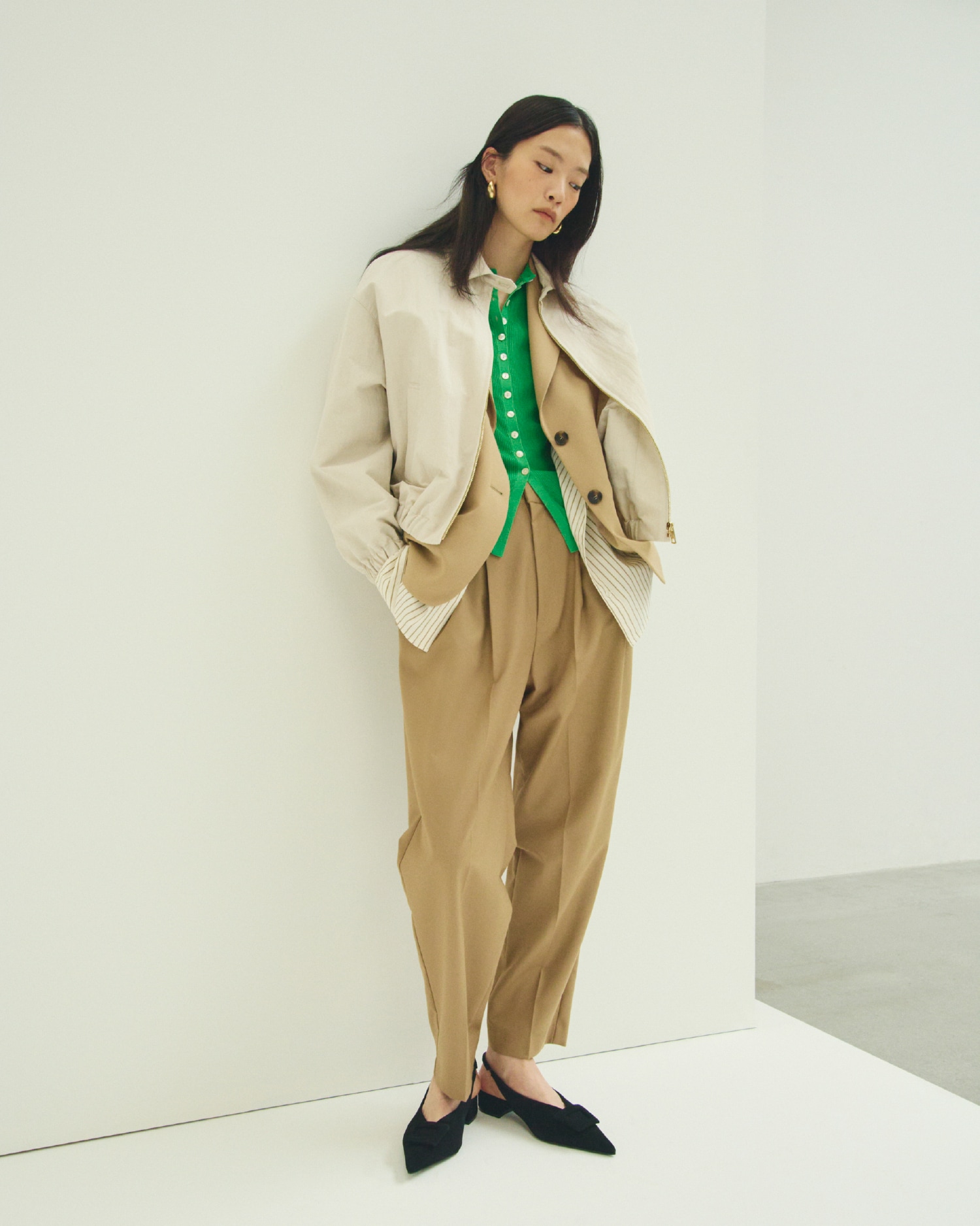 アイボリーのフォルムデザインスウィングトップ・ベージュのシャツレイヤードジャケット・グリーンのＵＶケアシアーリブニットカーディガン・キャメルの２タックテーパードパンツ・ゴールドのメタルドロップフープイヤリング・黒のバックル付きラムレザースリングパンプスを合わせたコーディネート