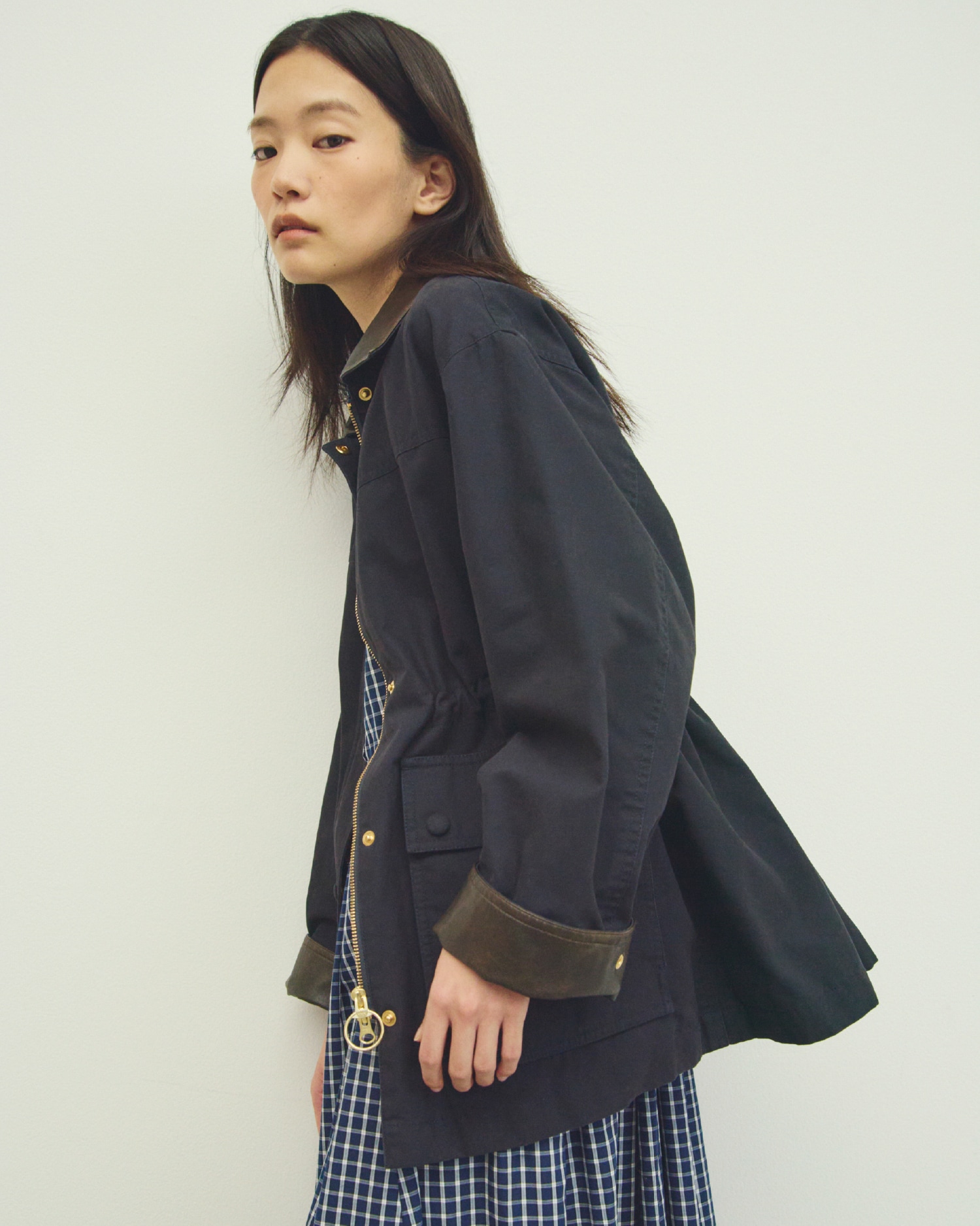 ダークネイビーのハーフ丈ハンティングジャケット・ネイビーのスリーブレスマキシ丈シャツワンピース・ベージュのエスパドリーユシューズを合わせたコーディネート