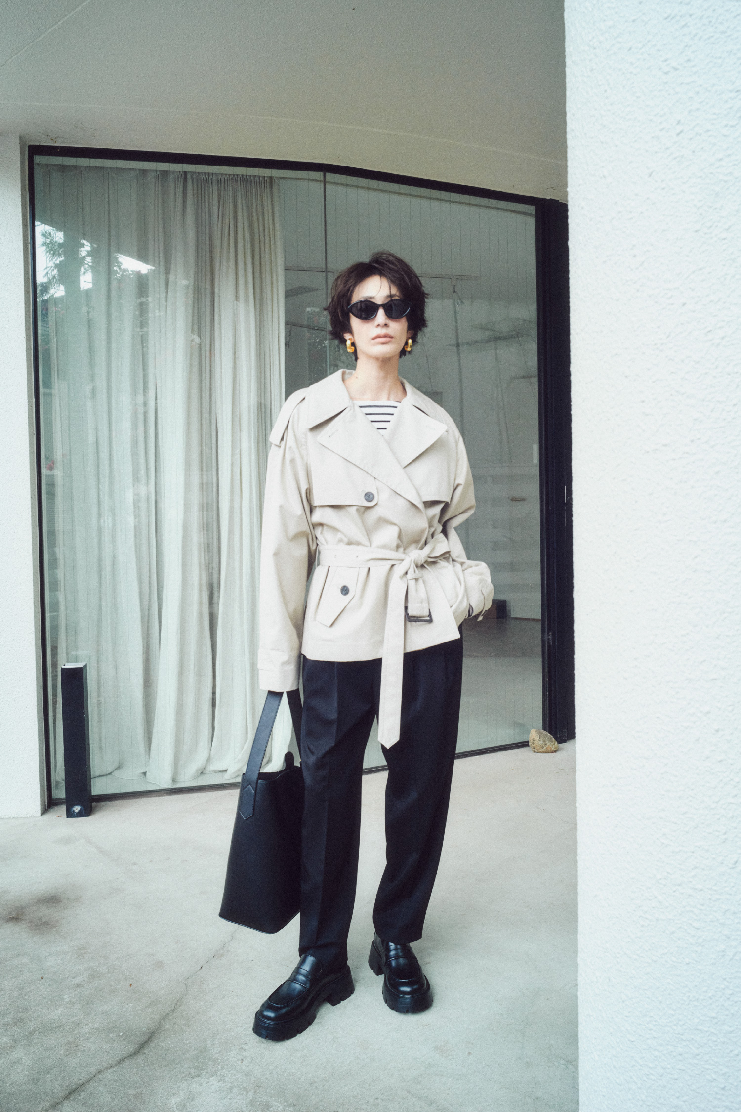 ショートトレンチコート、ボートネックボーダーＴシャツ、２タックテーパードＰＴ、キャットアイサングラス、メタルドロップフープイヤリング、バックルモチーフバケットバッグ、モカシンローファーの着用イメージ