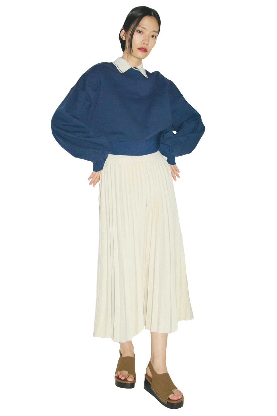 ネイビーのフォルムスリーブショートトレーナー・アイボリーのポロ衿リブニットカーディガンとニットプリーツスカート・白のパールチョーカーネックレス・キャメルのトングサンダルを合わせたコーディネート