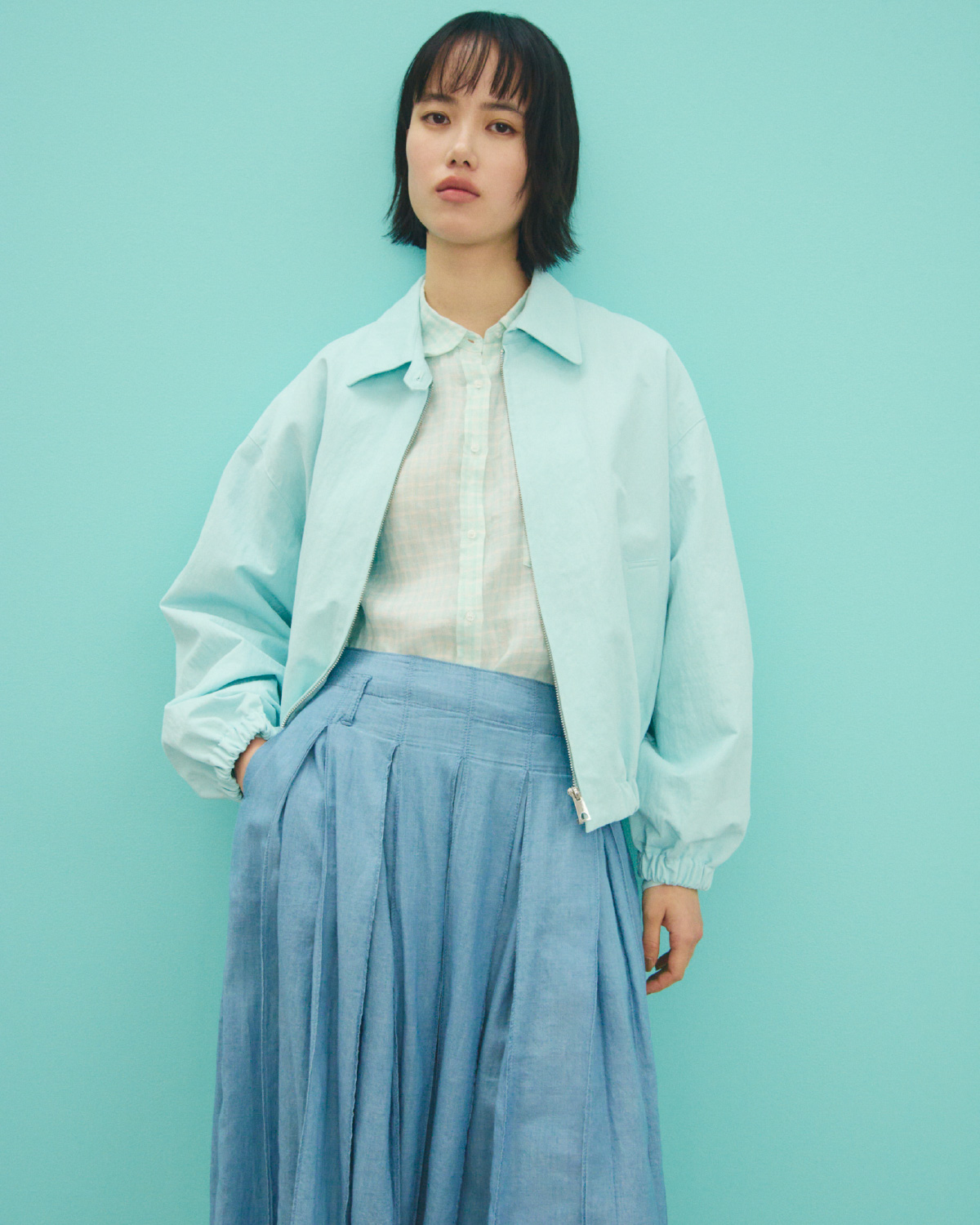 青色のフォルムデザインスウィングトップとシアーデニムタックプリーツスカート、ミント色のポケット付きフレンチリネンＳＨを合わせたコーディネート