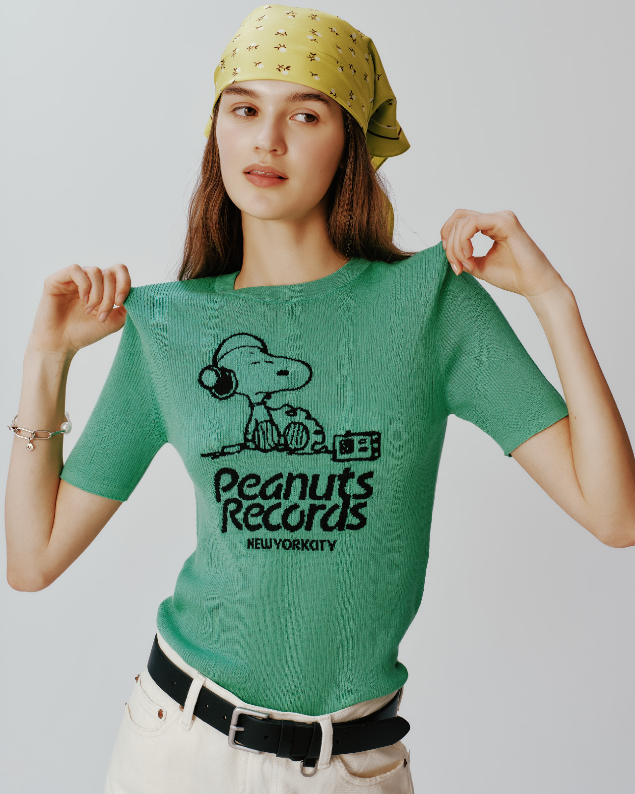 緑色のＰＥＡＮＵＴジャガードリブニットＴＯＰ、ヴィンテージストレートデニム、小花柄ラインスカーフ、スクエアダブルサルカンベルト、パールチェーンブレスを着用した女性の画像